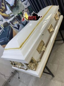 white casket with gold accent on top